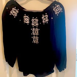 Black top with white embroidery.